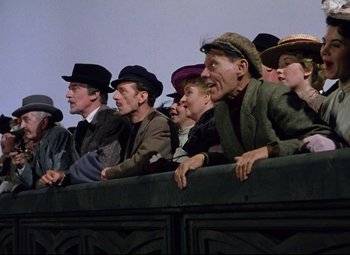 Movie still from “Million Dollar Mermaid” (1952), directed by Mervyn LeRoy – A group of people sitting on top of a fence; Medium shot, Low angle