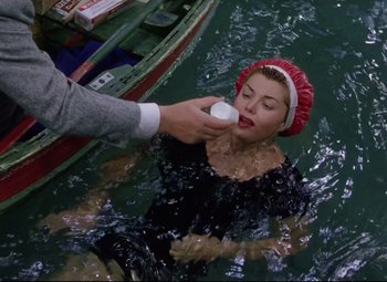 Movie still from “Million Dollar Mermaid” (1952), directed by Mervyn LeRoy – A woman in the water being given a lotion by a man; Close Up shot, Overhead angle