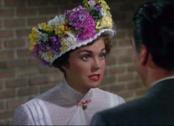 Movie still from “Million Dollar Mermaid” (1952), directed by Mervyn LeRoy – A woman wearing a hat with flowers on top of her head; Close Up shot, Over the shoulder angle