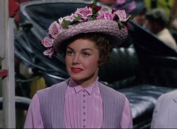 Movie still from “Million Dollar Mermaid” (1952), directed by Mervyn LeRoy – A woman wearing a hat with flowers on top of her head; Close Up shot, Over the shoulder angle