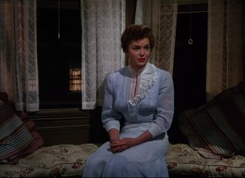 Movie still from “Million Dollar Mermaid” (1952), directed by Mervyn LeRoy – A woman sitting on top of a couch in a room; Medium shot, High angle