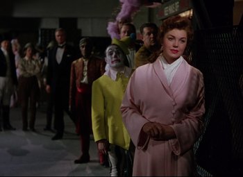Movie still from “Million Dollar Mermaid” (1952), directed by Mervyn LeRoy – A group of people standing in a line with a clown; Medium shot, Over the shoulder angle