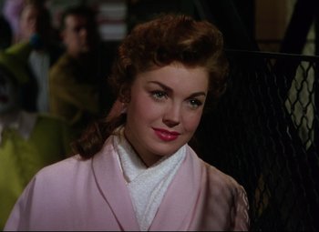 Movie still from “Million Dollar Mermaid” (1952), directed by Mervyn LeRoy – A woman in a pink coat and white shirt; Close Up shot, Over the shoulder angle