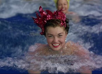Movie still from “Million Dollar Mermaid” (1952), directed by Mervyn LeRoy – Two women in a pool of water wearing fancy clothing; Close Up shot, High angle