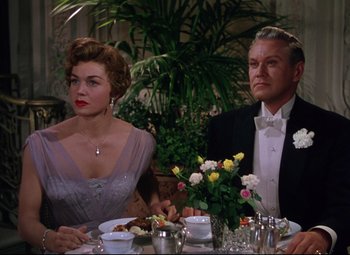 Movie still from “Million Dollar Mermaid” (1952), directed by Mervyn LeRoy – An older couple sitting at a dinner table; Medium shot, Low angle