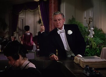 Movie still from “Million Dollar Mermaid” (1952), directed by Mervyn LeRoy – A man sitting at a table in front of other people; Medium shot, Low angle