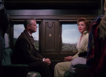 Movie still from “Million Dollar Mermaid” (1952), directed by Mervyn LeRoy – A man and a woman sitting on a train; Medium shot, Low angle