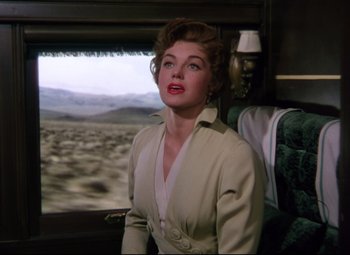 Movie still from “Million Dollar Mermaid” (1952), directed by Mervyn LeRoy – A woman sitting on a train looking out the window; Medium shot, Low angle