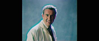 Movie still from “Mindhorn” (2016), directed by Sean Foley – A man in a white lab coat and a tie; Medium shot, Low angle