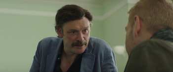 Movie still from “Mindhorn” (2016), directed by Sean Foley – A person with a mustache; Close Up shot, Over the shoulder angle