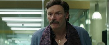 Movie still from “Mindhorn” (2016), directed by Sean Foley – A person with a mustache wearing a jacket; Close Up shot, Over the shoulder angle