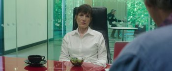 Movie still from “Mindhorn” (2016), directed by Sean Foley – A woman sitting at a table with a bowl of salad in front of her; Medium shot, Over the shoulder angle