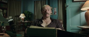 Movie still from “Mindhorn” (2016), directed by Sean Foley – A bald man sitting in front of an open box; Medium shot, Low angle