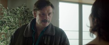 Movie still from “Mindhorn” (2016), directed by Sean Foley – A person wearing a jacket; Close Up shot, Over the shoulder angle