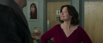 Movie still from “Mindhorn” (2016), directed by Sean Foley – A woman in a red shirt looking up at the ceiling; Medium shot, Over the shoulder angle