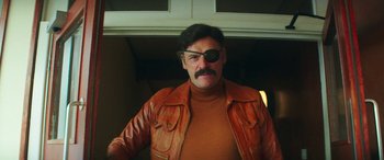 Movie still from “Mindhorn” (2016), directed by Sean Foley – A man wearing a brown leather jacket and a pirate eye patch; Close Up shot, Low angle
