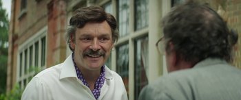 Movie still from “Mindhorn” (2016), directed by Sean Foley – A person with a beard and mustache; Close Up shot, Over the shoulder angle