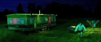 Movie still from “Mindhorn” (2016), directed by Sean Foley – A trailer parked in the grass at night; Extreme Wide shot, Low angle