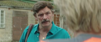 Movie still from “Mindhorn” (2016), directed by Sean Foley – A person with a beard and mustache; Close Up shot, Over the shoulder angle