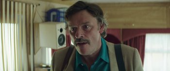 Movie still from “Mindhorn” (2016), directed by Sean Foley – A person with a beard and mustache; Close Up shot, Over the shoulder angle