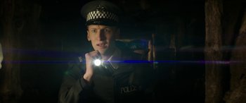 Movie still from “Mindhorn” (2016), directed by Sean Foley – A man in uniform holding a flashlight in a dark room; Close Up shot, Low angle