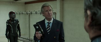 Movie still from “Mindhorn” (2016), directed by Sean Foley – An older man in a suit and tie holding a vhs tape; Close Up shot, Low angle