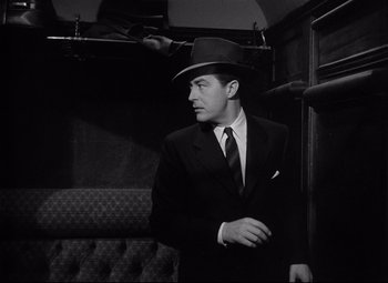 Movie still from “Ministry of Fear” (1944), directed by Fritz Lang – A black and white photo of a man in a suit and hat; Medium shot, Low angle