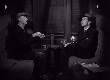 Movie still from “Ministry of Fear” (1944), directed by Fritz Lang – Two men sitting in a room talking to each other; Medium shot, High angle