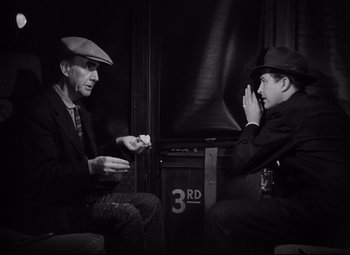 Movie still from “Ministry of Fear” (1944), directed by Fritz Lang – Two men sitting in front of each other; Medium shot, High angle