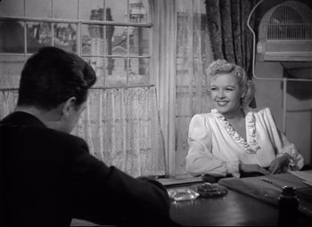 Movie still from “Ministry of Fear” (1944), directed by Fritz Lang – A woman sitting at a table talking to a man; Medium shot, Over the shoulder angle