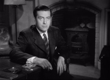 Movie still from “Ministry of Fear” (1944), directed by Fritz Lang – A black and white photo of a man in a suit and tie; Medium shot, Low angle