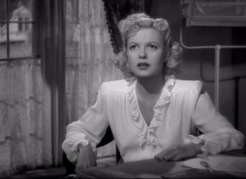 Movie still from “Ministry of Fear” (1944), directed by Fritz Lang – A black and white photo of a woman sitting at a table; Close Up shot, Over the shoulder angle
