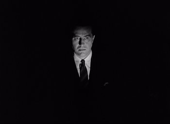 Movie still from “Ministry of Fear” (1944), directed by Fritz Lang – A black and white photo of a man wearing a suit and tie; Close Up shot, Low angle