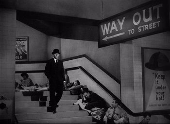Movie still from “Ministry of Fear” (1944), directed by Fritz Lang – A black and white photo of a man walking up stairs; Wide shot, Low angle