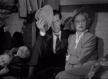 Movie still from “Ministry of Fear” (1944), directed by Fritz Lang – A man and a woman sitting next to each other; Medium shot, High angle