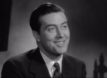 Movie still from “Ministry of Fear” (1944), directed by Fritz Lang – A man in a suit and tie smiling for the camera; Close Up shot, Low angle