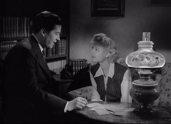 Movie still from “Ministry of Fear” (1944), directed by Fritz Lang – A man and a woman sitting at a table with papers; Medium shot, High angle