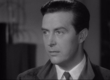 Movie still from “Ministry of Fear” (1944), directed by Fritz Lang – A black and white photo of a man in a suit and tie; Close Up shot, Over the shoulder angle