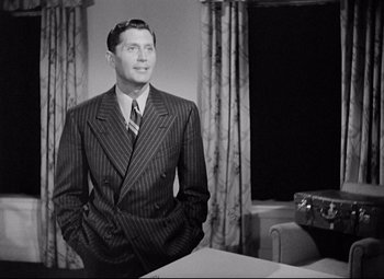 Movie still from “Ministry of Fear” (1944), directed by Fritz Lang – A man in a suit standing in front of a window; Medium shot, Low angle
