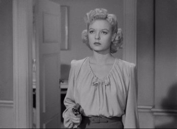 Movie still from “Ministry of Fear” (1944), directed by Fritz Lang – A black and white photo of a woman holding a gun; Medium shot, Low angle