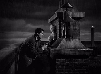 Movie still from “Ministry of Fear” (1944), directed by Fritz Lang – A man and a woman standing next to each other on top of a building; Medium shot, Low angle