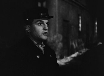 Movie still from “Miracle in Milan” (1951), directed by Vittorio De Sica – Black and white photograph of a man wearing a hat; Close Up shot, Low angle