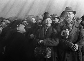 Movie still from “Miracle in Milan” (1951), directed by Vittorio De Sica – A group of men standing next to each other; Medium shot, Low angle