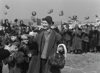 Movie still from “Miracle in Milan” (1951), directed by Vittorio De Sica – An old photo of a crowd of people throwing balls; Medium shot, Low angle