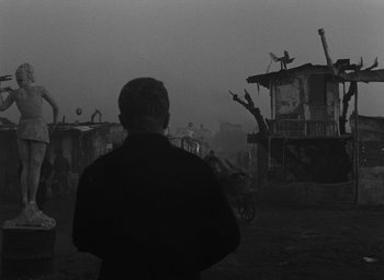 Movie still from “Miracle in Milan” (1951), directed by Vittorio De Sica – A man standing in the middle of a field; Wide shot, Low angle