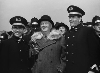 Movie still from “Miracle in Milan” (1951), directed by Vittorio De Sica – A group of men standing next to each other; Medium shot, Low angle