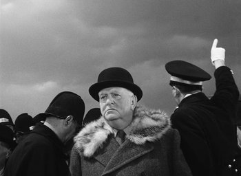 Movie still from “Miracle in Milan” (1951), directed by Vittorio De Sica – An older man wearing a coat and a hat; Medium shot, Low angle