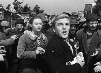 Movie still from “Miracle in Milan” (1951), directed by Vittorio De Sica – A group of people standing in front of a crowd; Medium shot, Low angle
