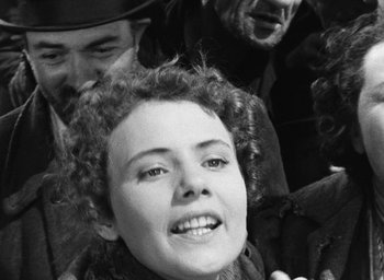 Movie still from “Miracle in Milan” (1951), directed by Vittorio De Sica – An old black and white photo of a woman smiling; Close Up shot, High angle