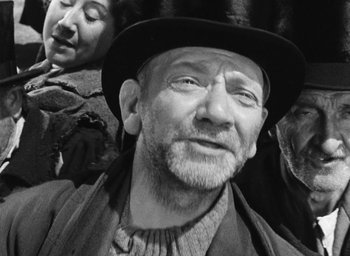 Movie still from “Miracle in Milan” (1951), directed by Vittorio De Sica – An old man wearing a black hat and a beard; Close Up shot, Low angle